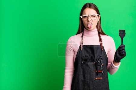 Téléchargez les photos : Jeune jolie femme se sentant dégoûtée et irritée et la langue. concept de sèche-cheveux - en image libre de droit