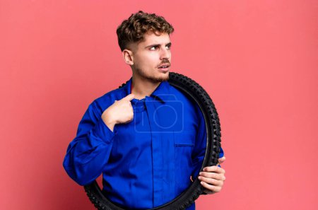 Téléchargez les photos : Jeune homme caucasien adulte se sentant stressé, anxieux, fatigué et frustré. réparation de vélo ou concept de mécanicien - en image libre de droit
