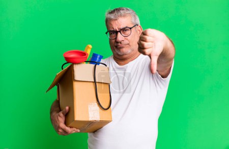 Photo for Middle age senior man feeling cross,showing thumbs down. housekeeper repairman with a toolbox concept - Royalty Free Image