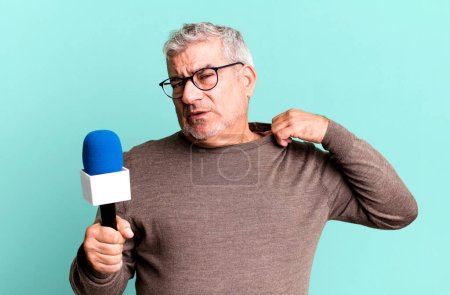 Photo for Middle age senior man feeling stressed, anxious, tired and frustrated. journalist or tv presenter with a micro - Royalty Free Image