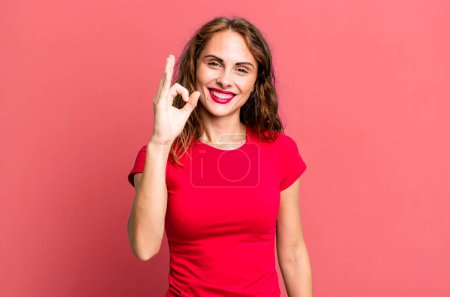 Photo for Young pretty woman feeling happy, relaxed and satisfied, showing approval with okay gesture, smiling - Royalty Free Image
