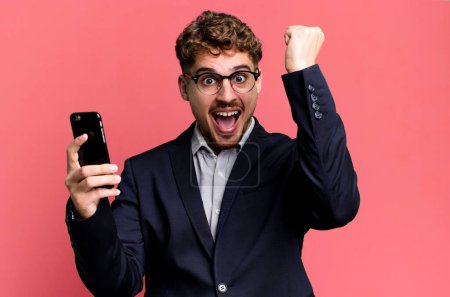 Téléchargez les photos : Young adult caucasian businessman with a smartphone - en image libre de droit