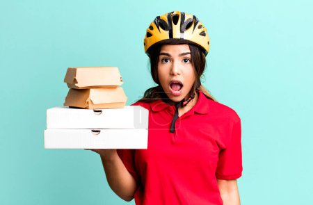 Photo for Hispanic pretty woman looking very shocked or surprised.  delivery woman and take away concept - Royalty Free Image