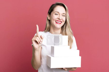 Foto de Sonriendo orgullosa y confiadamente haciendo el número uno. concepto de cajas blancas - Imagen libre de derechos