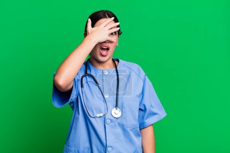 Photo for Looking shocked, scared or terrified, covering face with hand. nurse concept - Royalty Free Image