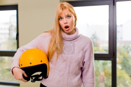 Foto de Joven bonita mujer con un casco de moto en el interior de casa - Imagen libre de derechos