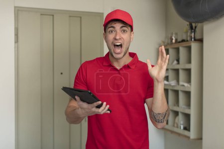 Photo for Young handsome man feeling happy and astonished at something unbelievable. delivery man concept - Royalty Free Image