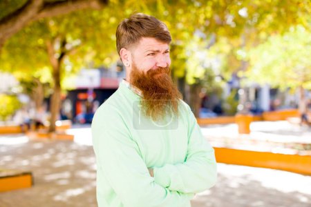 Photo for Red hair bearded man wondering, thinking happy thoughts and ideas, daydreaming, looking to copy space on side - Royalty Free Image