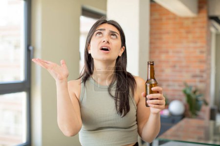 Photo for Young woman screaming with hands up in the air. beer bottle - Royalty Free Image