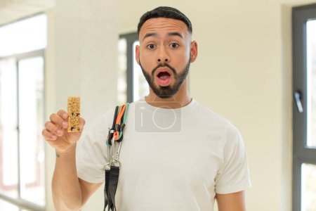Photo for Arab handsome man arab man feeling extremely shocked and surprised.  fitness and cereal bar concept - Royalty Free Image