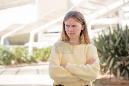 Photo for Pretty young woman feeling displeased and disappointed, looking serious, annoyed and angry with crossed arms - Royalty Free Image
