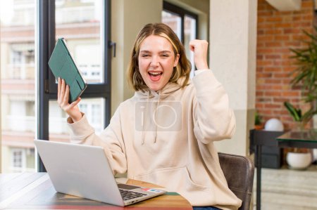 Téléchargez les photos : Jolie jeune femme avec un ordinateur portable travaillant à la maison. design intérieur de la maison - en image libre de droit