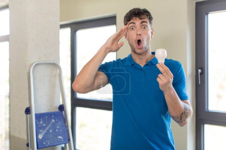 Photo for Young handsome man looking happy, astonished and surprised. handyman concept - Royalty Free Image