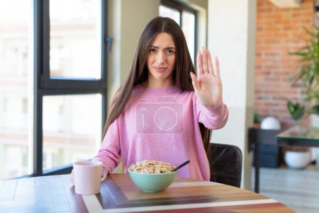 Foto de Mirando seriamente mostrando la palma abierta haciendo gesto de parada. concepto de desayuno - Imagen libre de derechos