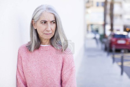 Photo for Senior retired pretty white hair woman wondering, thinking happy thoughts and ideas, daydreaming, looking to copy space on side - Royalty Free Image