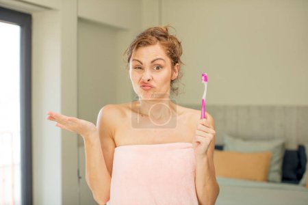 Photo for Young pretty woman shrugging, feeling confused and uncertain.  mouthwash concept - Royalty Free Image