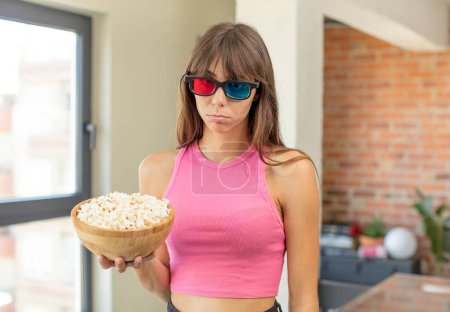 Photo for Young pretty woman feeling sad and whiney with an unhappy look and crying. popcorns movie concept - Royalty Free Image