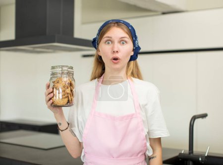 Photo for Young pretty woman feeling extremely shocked and surprised. home made cookies - Royalty Free Image