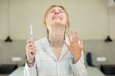 Photo for Young pretty woman screaming with hands up in the air. toothwash concept - Royalty Free Image