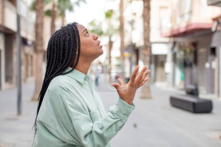 Foto de Afro bonita mujer negra buscando desesperado y frustrado, estresado, infeliz y molesto, gritando y gritando - Imagen libre de derechos
