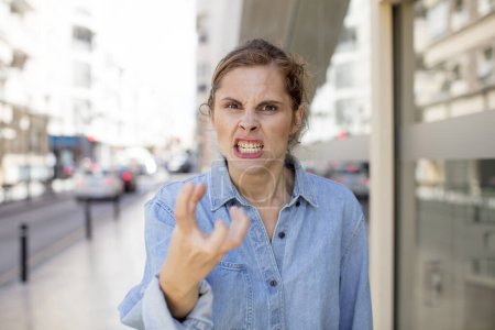 Foto de Bastante joven mujer mirando enojado, molesto y frustrado gritando wtf o lo que está mal con usted - Imagen libre de derechos