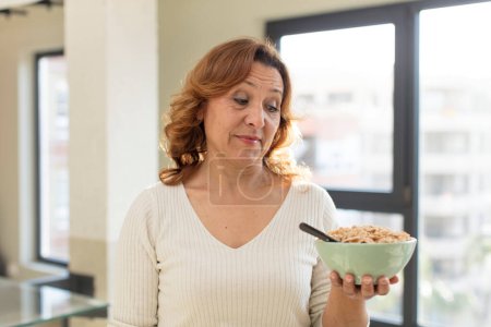 Foto de Mujer bonita de mediana edad sonriendo y mirando con una expresión de confianza feliz. concepto de plato de desayuno - Imagen libre de derechos