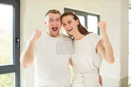Téléchargez les photos : Se sentir choqué, rire et célébrer le succès. concept de jeune couple - en image libre de droit