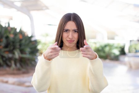 Photo for Young pretty woman pointing forward at camera with both fingers and angry expression, telling you to do your duty - Royalty Free Image