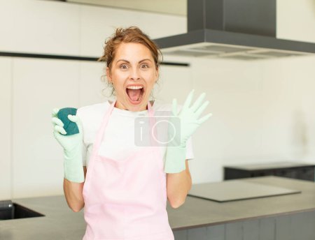 Photo for Young pretty woman feeling happy and astonished at something unbelievable. housekeeper concept - Royalty Free Image
