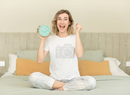 Foto de Mujer bonita sensación de shock, riendo y celebrando el éxito concepto de despertador - Imagen libre de derechos