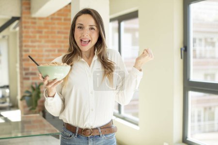 Foto de Mujer bonita sintiéndose conmocionada, riendo y celebrando el éxito. concepto de plato de desayuno - Imagen libre de derechos