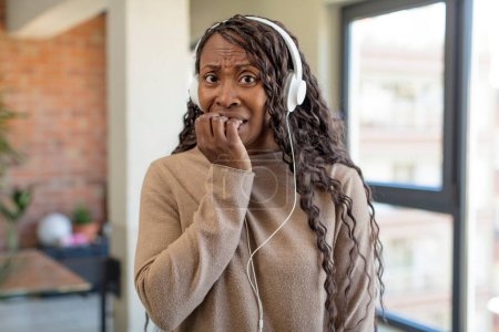 Téléchargez les photos : Femme afro noire se sentant effrayée, inquiète ou en colère et regardant vers le côté. concept de musique d'écoute - en image libre de droit