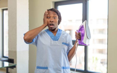 Photo for Black afro woman feeling extremely shocked and surprised. laundry and housekeeping concept - Royalty Free Image