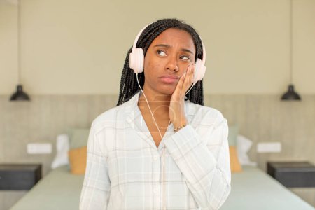 Foto de Negro afro mujer sintiéndose aburrido, frustrado y soñoliento después de un cansancio. concepto de descanso y ropa de dormir - Imagen libre de derechos