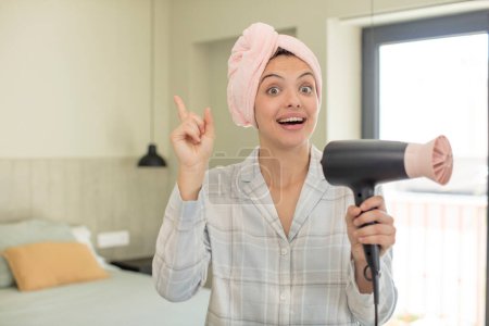 Téléchargez les photos : Young pretty woman feeling like a happy and excited genius after realizing an idea. hair dryer concept - en image libre de droit
