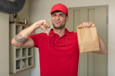 Photo for Young handsome man feeling cross,showing thumbs down. delivery man concept - Royalty Free Image