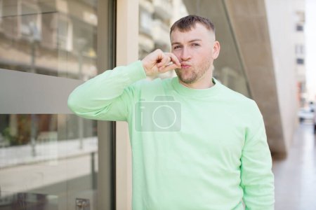 Photo for Handsome man looking serious and displeased with both fingers crossed up front in rejection, asking for silence - Royalty Free Image