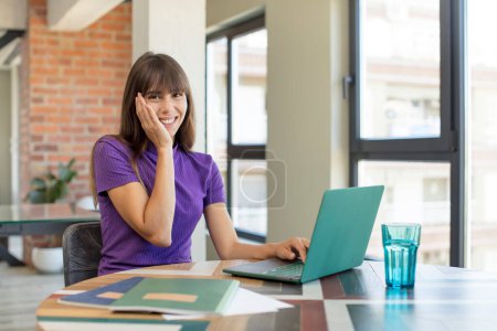 Foto de Joven bonita mujer sintiéndose feliz y asombrada por algo increíble. estudiante universitario con un ordenador portátil - Imagen libre de derechos