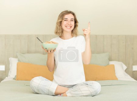 Foto de Mujer bonita sentirse como un genio feliz y emocionado después de darse cuenta de una idea. tazón de desayuno - Imagen libre de derechos