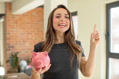 Photo for Pretty woman feeling like a happy and excited genius after realizing an idea. piggy bank - Royalty Free Image