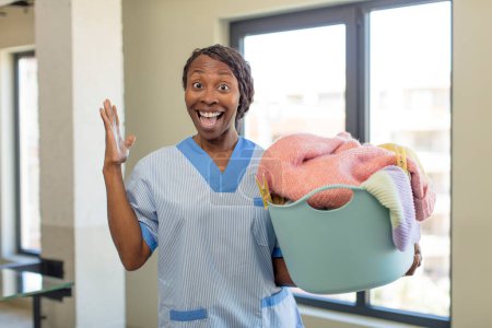 Foto de Negro afro mujer sintiéndose feliz y asombrado por algo increíble. concepto de lavandería y limpieza - Imagen libre de derechos