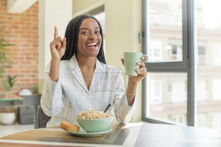 Foto de Negro afro mujer sintiéndose como un feliz y emocionado genio después de darse cuenta de una idea. concepto de desayuno - Imagen libre de derechos