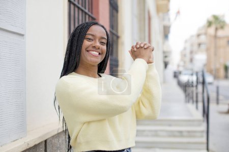 Téléchargez les photos : Afro jolie femme noire se sentant heureuse, surprise et fière, criant et célébrant le succès avec un grand sourire - en image libre de droit