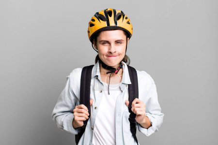 Photo for Young adult pretty delivery woman with bike helmet and bag - Royalty Free Image