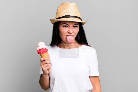 Foto de Mujer bonita hispana sintiéndose disgustada e irritada y con la lengua fuera. helados y concepto de verano - Imagen libre de derechos