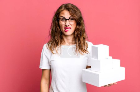 Foto de Mujer bonita hispana mirando perpleja y confundida. con cajas blancas paquetes - Imagen libre de derechos