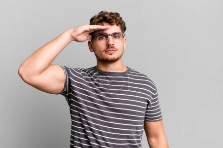 Téléchargez les photos : Young adult caucasian man greeting the camera with a military salute in an act of honor and patriotism, showing respect - en image libre de droit