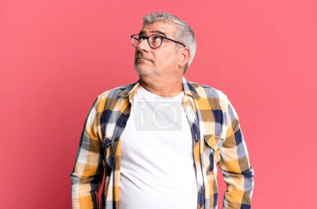 Photo for Middle age senior man with a worried, confused, clueless expression, looking up to copy space, doubting - Royalty Free Image