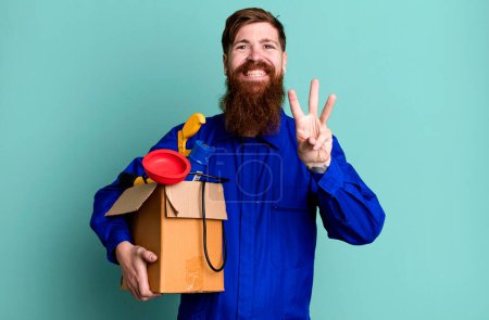 Foto de Barba larga hombre sonriendo y buscando amigable, mostrando el número tres. reparador con concepto de caja de herramientas - Imagen libre de derechos