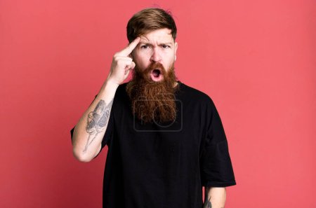 Téléchargez les photos : Barbe longue et cheveux roux homme regardant surpris, la réalisation d'une nouvelle pensée, idée ou concept - en image libre de droit